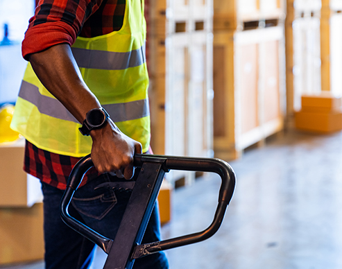 Close up worker hand pull hand pallet jack.