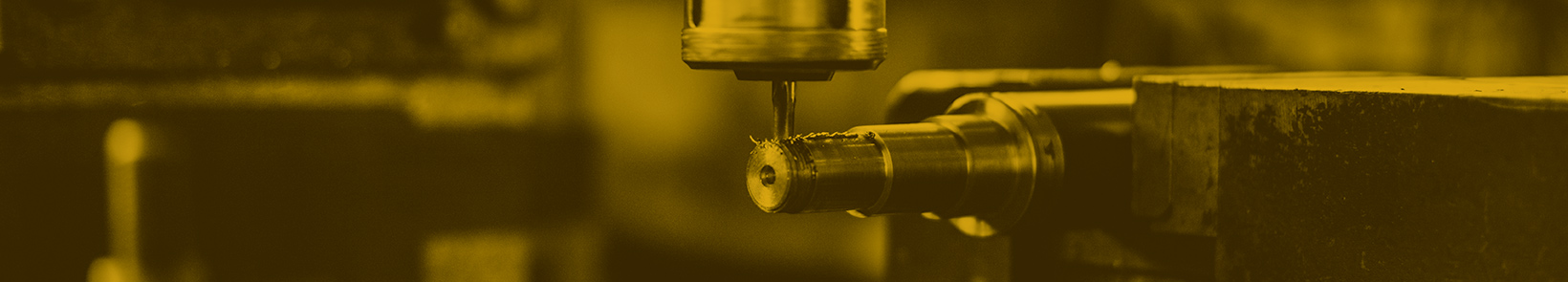 Industrial machinist operating CNC equipment in a manufacturing facility.