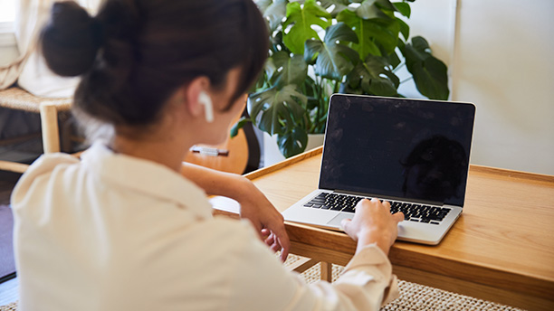 Young woman video chatting online with a laptop at home