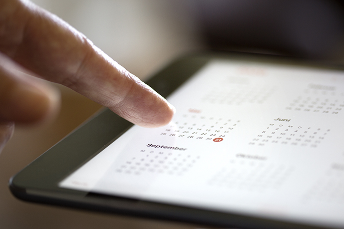 Index finger pointing to a date on an electronic calendar