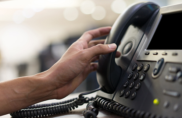 Office staffing employee reaching for a phone